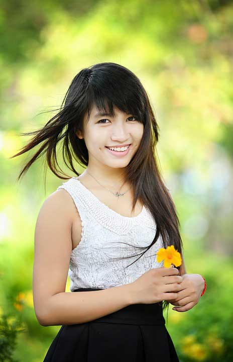 Asian girl smiling holding a flower